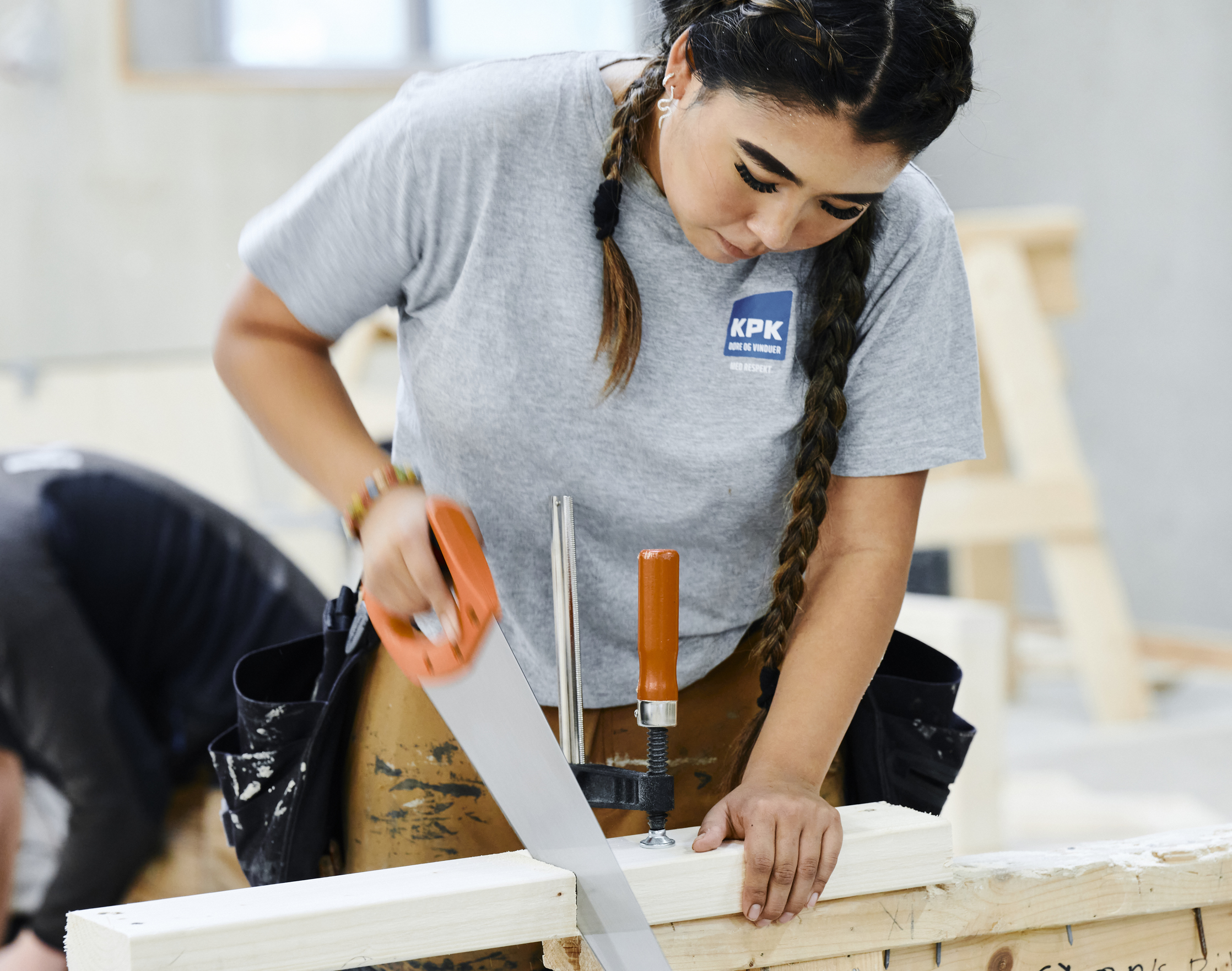 Pige i arbejdstøj saver