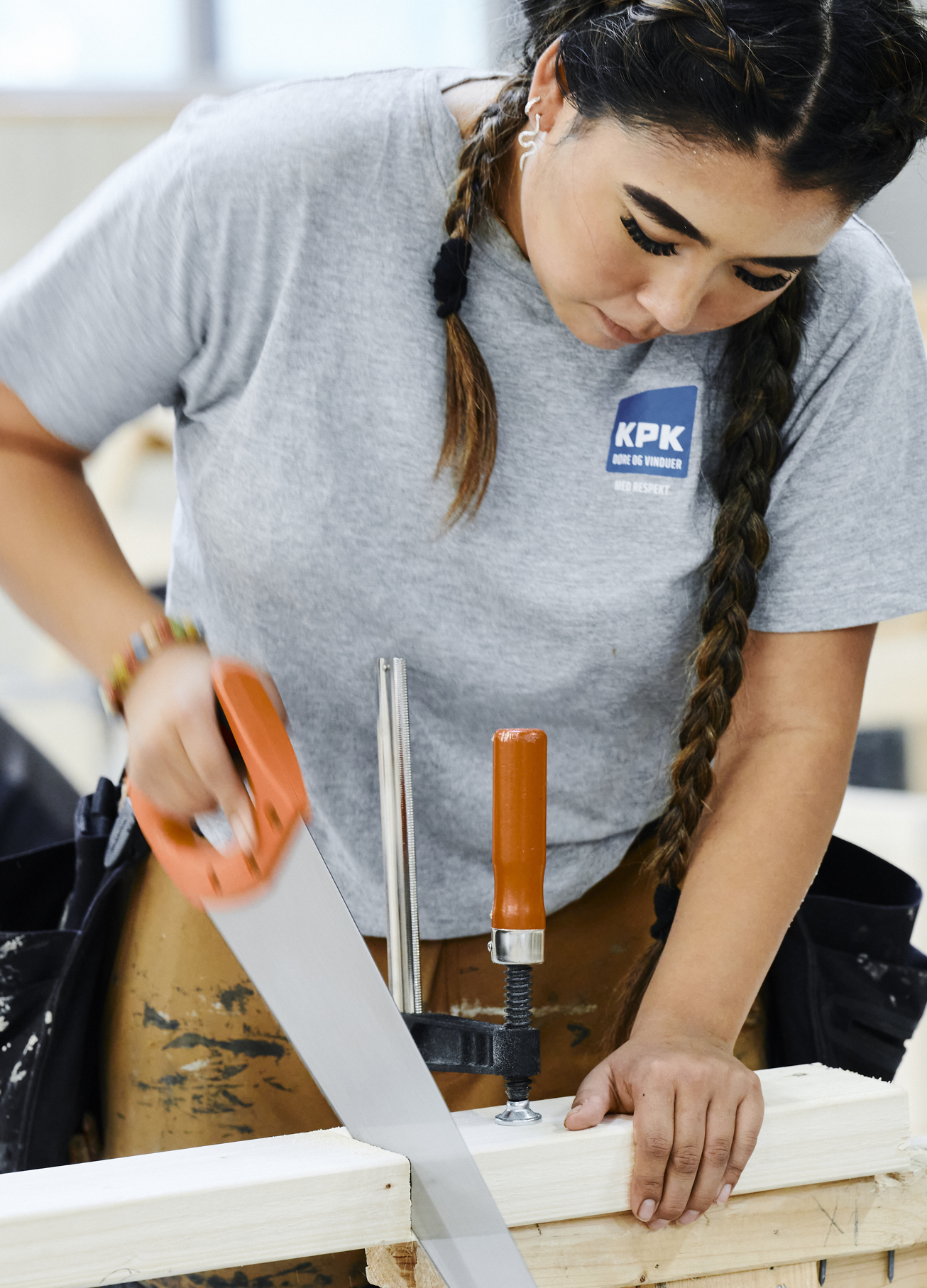 Pige i arbejdstøj saver