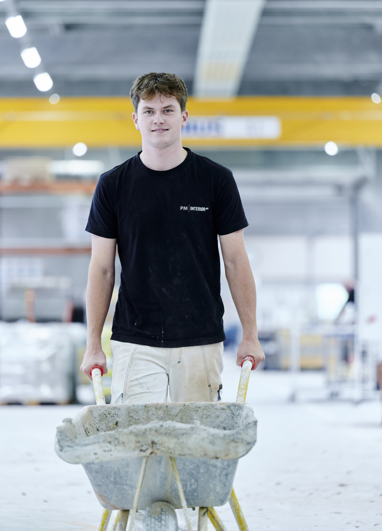 Murerelev går med trillebør