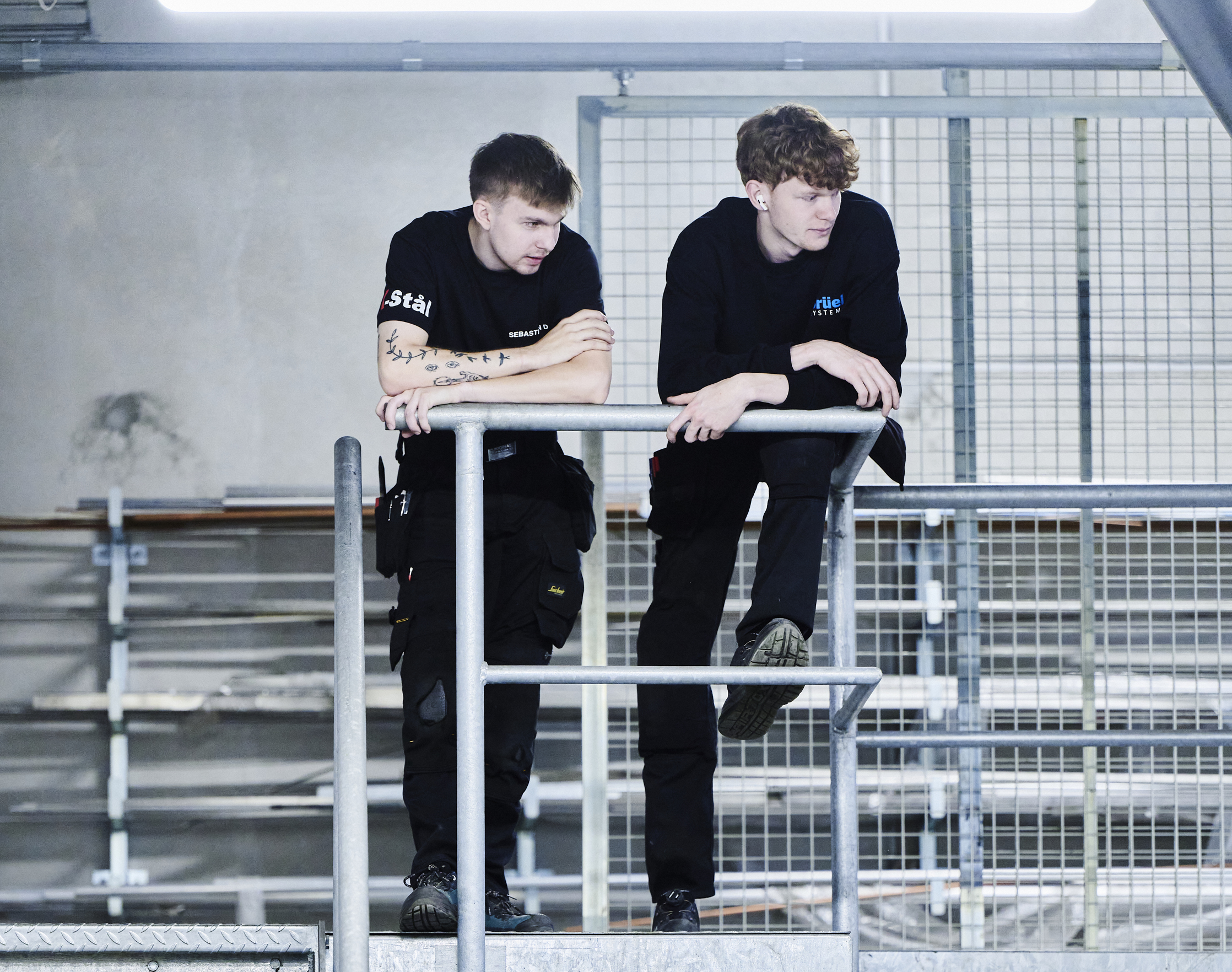 Smede-drenge stå oppe på trappe og kigger ud over værkstedet