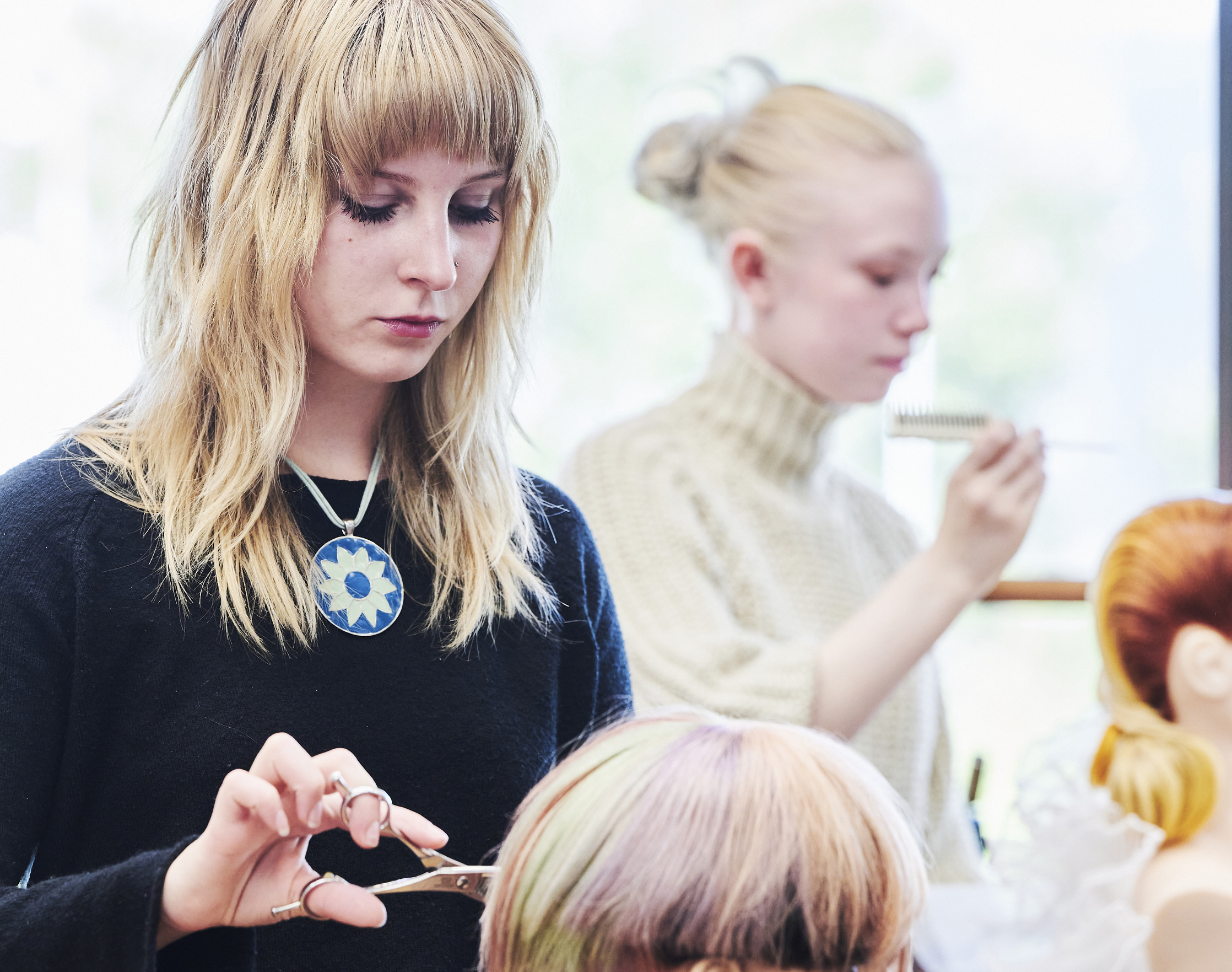 Elev klipper hår på øvelseshovede