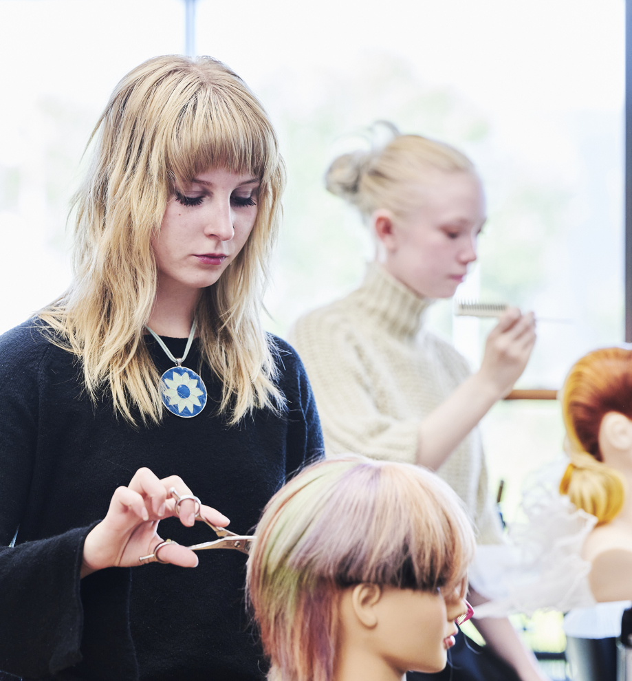 Elev klipper hår på øvelseshovede