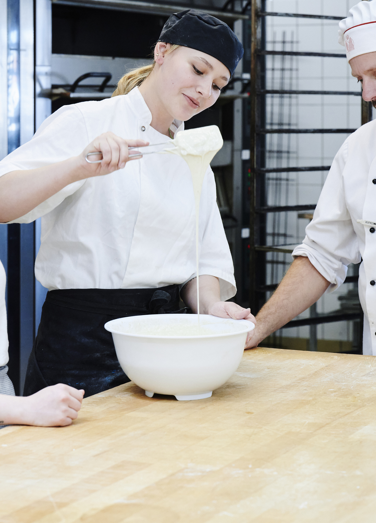 Bagerelever og faglærer kigger på dej