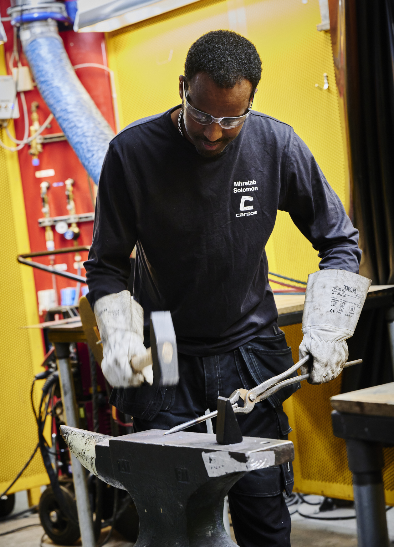 Smedeelev hamrer på jern