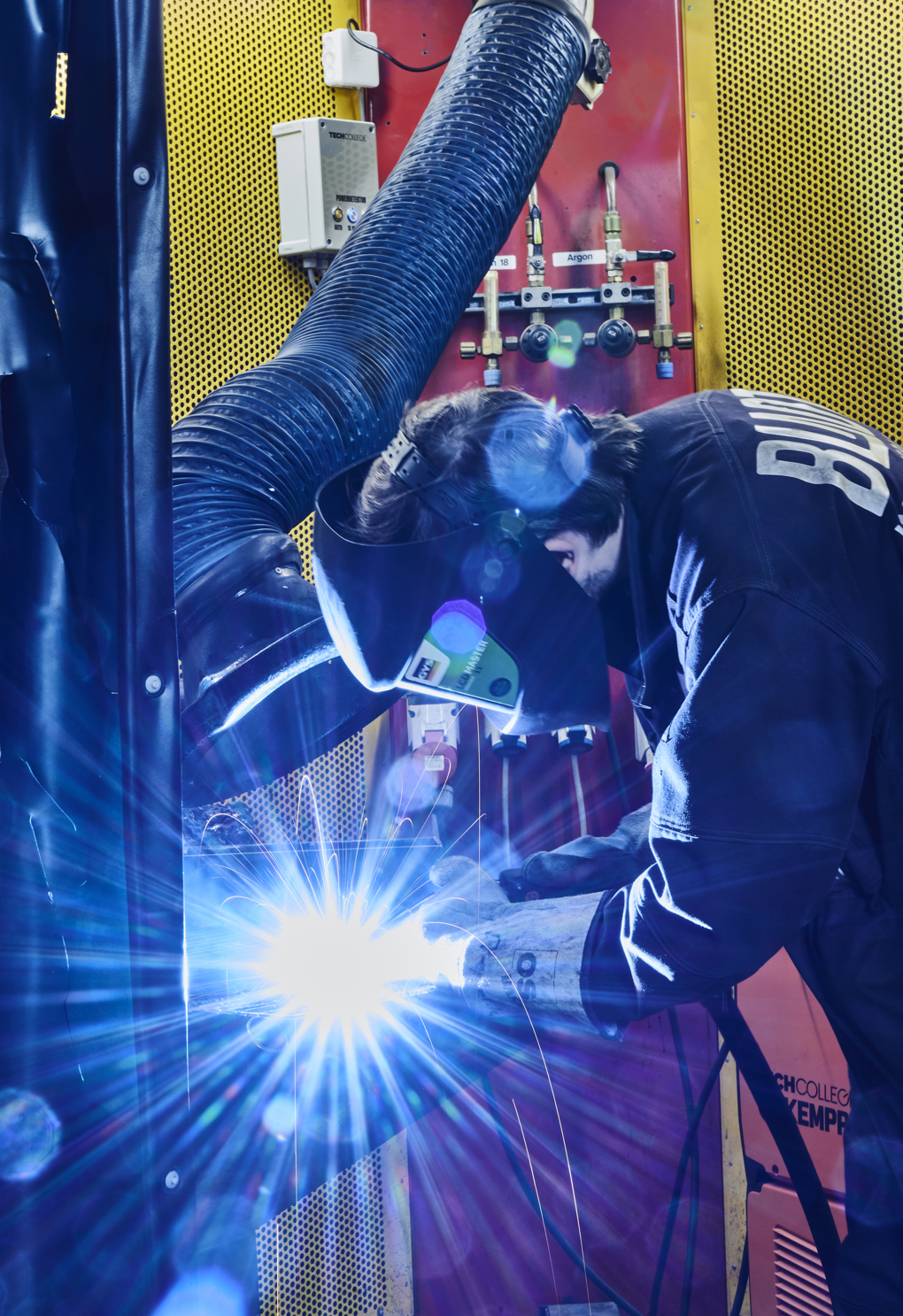 Smedeelev svejser i svejsekabine 