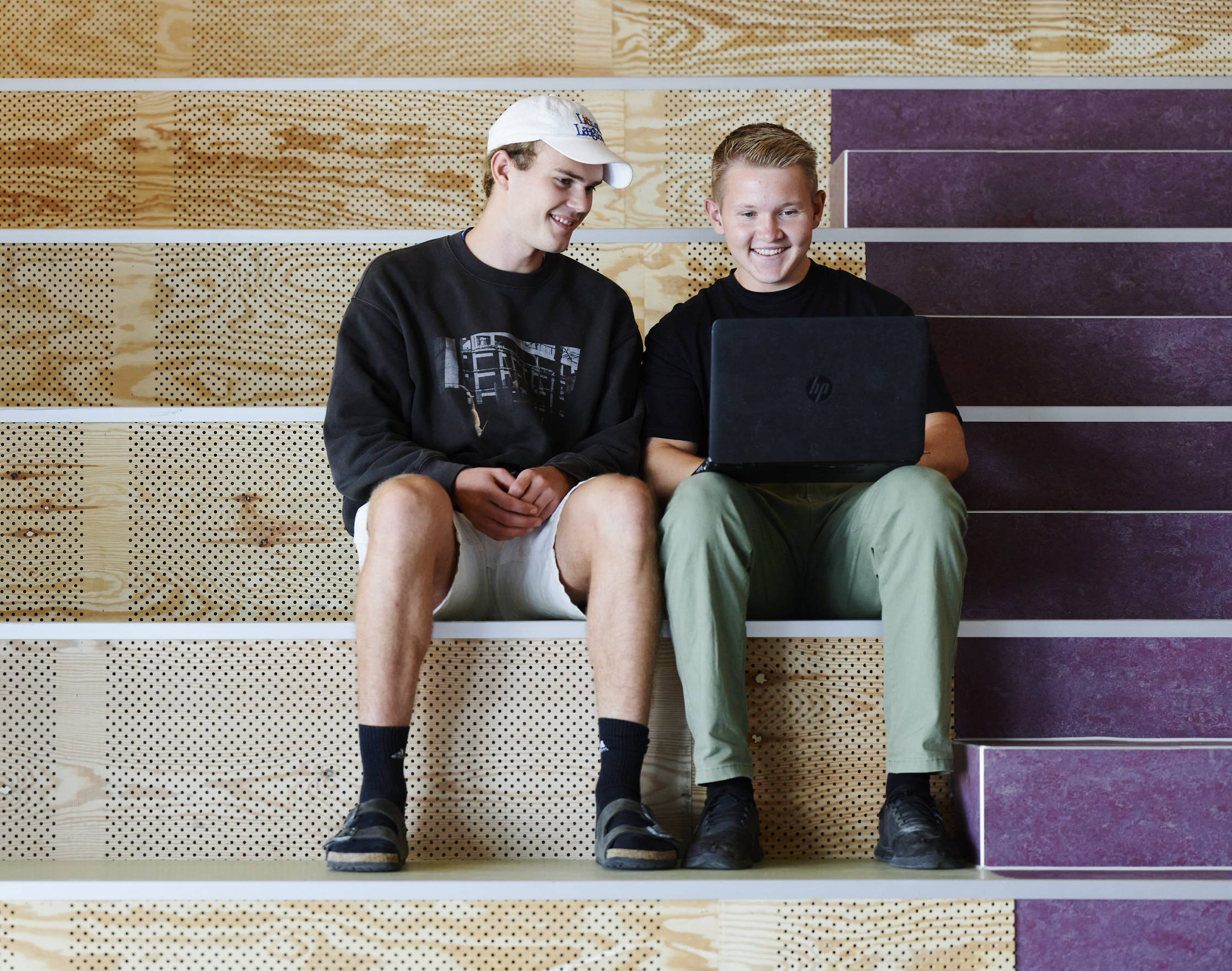 Elever sidder i studiemiljø med computer