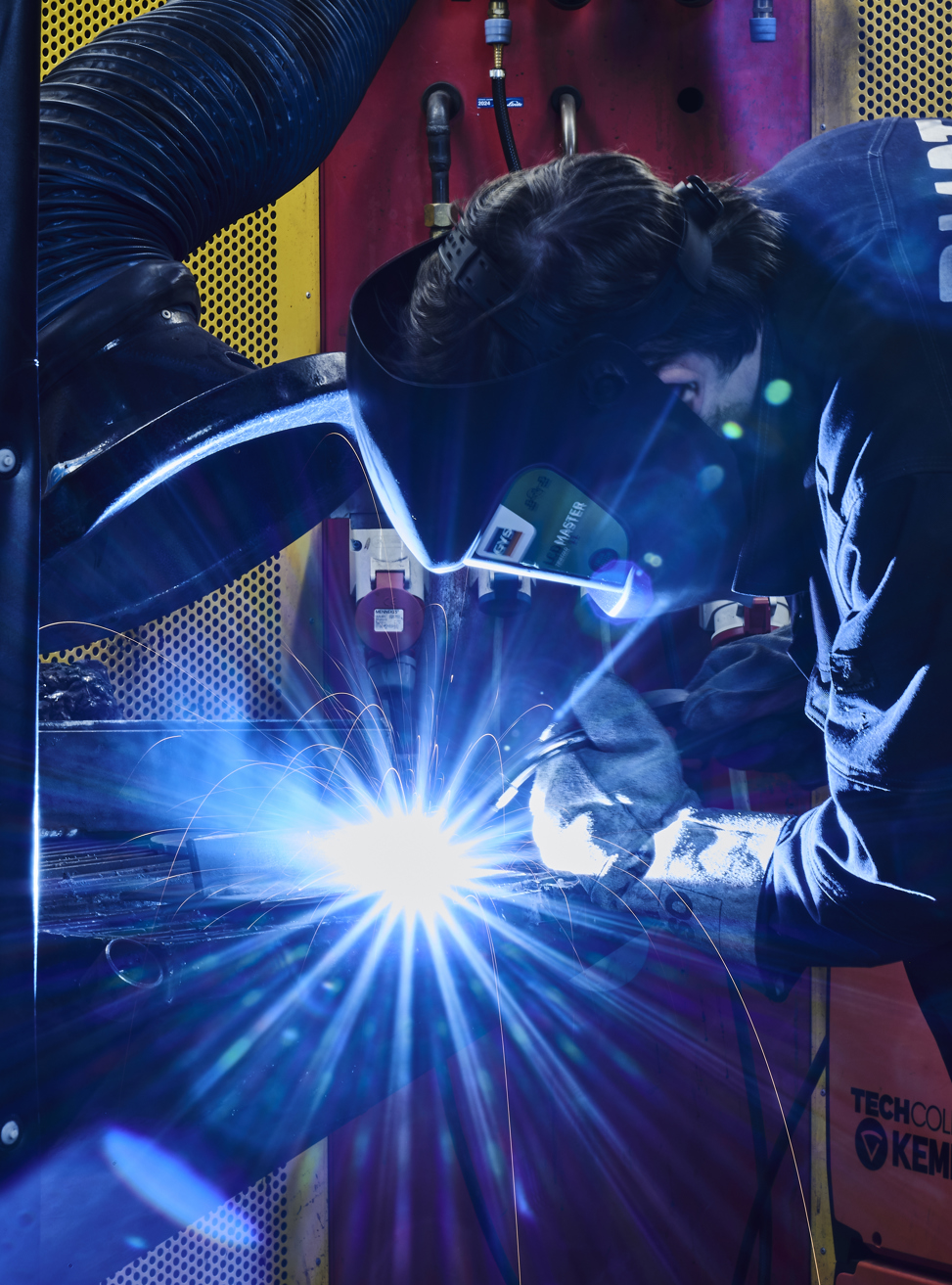 Smedeelev svejser i svejsekabine 