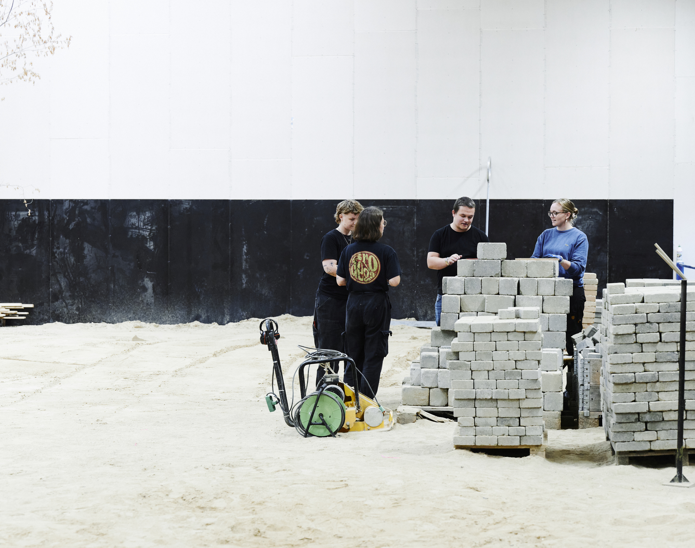 Anlægsgartner-elever i stor hal med sand